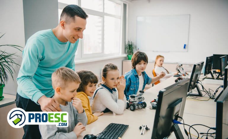 Internet das Coisas na escola: imagem mostra professor em uma sala com crianças utilizando computadores.