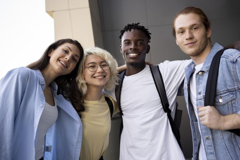 Quatro jovens se abraçando, representando um bom clima escolar.