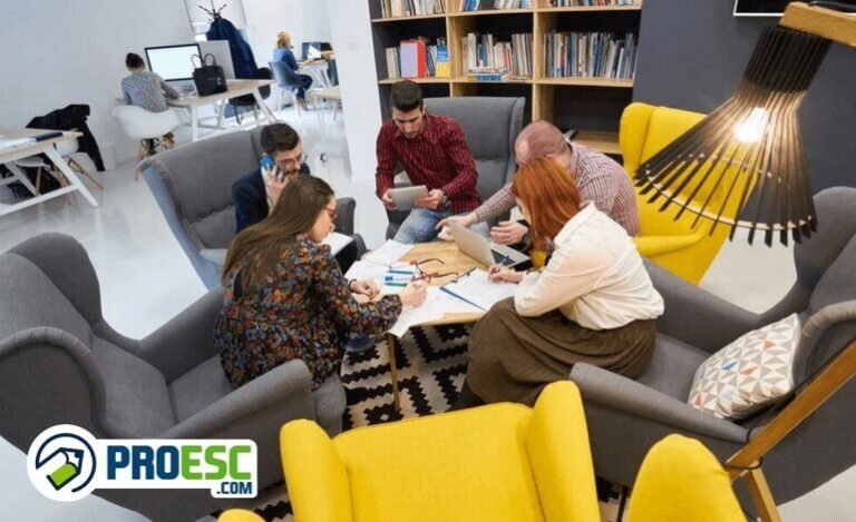 Professores elaborando o projeto político pedagógico da escola em volta de uma mesa na sala de professores.