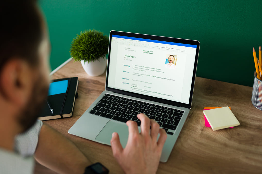 Homem utilizando computador com sistema de gestão escolar para rematrícula online.